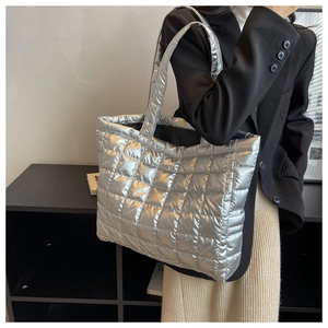 Close-up of metallic silver quilted tote bag with large puffer diamond stitching design