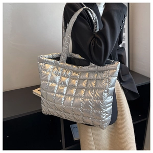 Silver metallic quilted tote bag shown on a model from a stylish side-back view