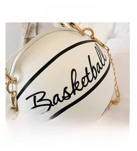Detail shot of white basketball-shaped handbag with golden chain strap and leather texture