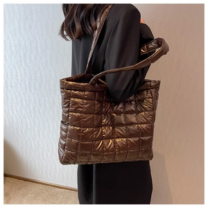Detail of coffee brown quilted puffer tote bag in glossy nylon with padded texture