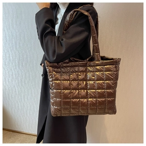 Close-up of quilted coffee brown tote bag with glossy finish on a shoulder strap