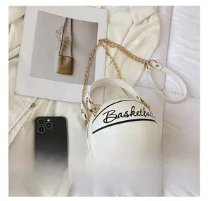 Size comparison of white basketball-shaped chain purse next to a smartphone