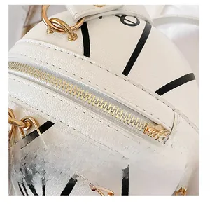 Detail showing high-quality smooth gold metal zipper on white basketball chain bag