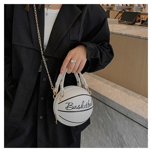 Detail of unique white basketball-shaped crossbody bag with gold chain and handle