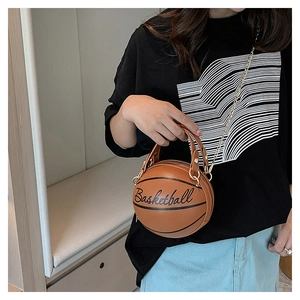 Detailed view of a brown basketball-shaped crossbody bag with gold chain and top handle