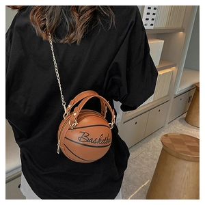 Detail of a brown leather basketball-shaped crossbody bag with gold chain and text