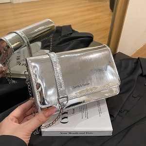 Silver metallic crossbody bag with chain strap and reflective mirror finish surface