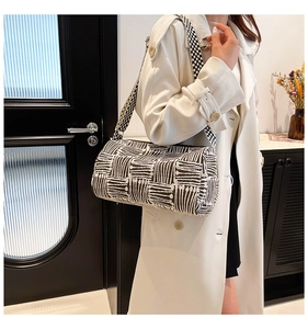 Detail of the black and white geometric pattern on the canvas bucket bag with wide strap