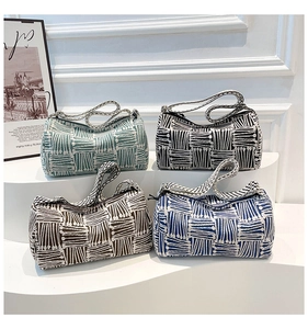 Close-up of four colored cylinder canvas bags with woven texture on display stands