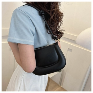 Vue latérale d'un sac sous les aisselles noir avec design rembourré et nœuds