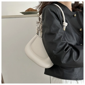 Détail du sac bandoulière blanc avec lanière nouée et boucles en métal doré poli