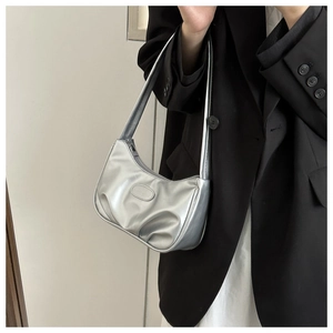 Détail du sac à bandoulière demi-lune argenté avec fini métallisé et design plissé