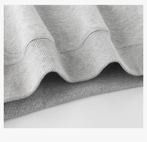 Detail shot of the heather grey ribbed hem and soft cotton knit fabric on the sweatshirt