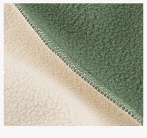 Detail of soft green and cream fleece fabric showing high-quality stitching and texture