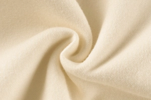Macro view showing the soft texture and spiral folds of off-white fleece knit fabric