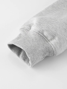 Primer plano de sudadera de forro polar gris claro con puños acanalados y costuras