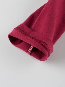 Close-up of deep red long-sleeved kids' T-shirt sleeve with fine white stitching details