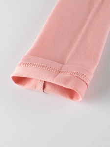 Dettaglio del polsino della t-shirt rosa a maniche lunghe con trama in cotone e cuciture