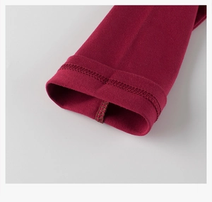 Detailed close-up of knit fabric and professional double-needle stitching on red shirt sleeve