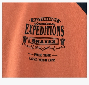 Detail of cotton orange raglan t-shirt featuring black vintage outdoor expedition prints