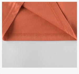 Macro shot of double-needle stitching and fine cotton texture on boy's long-sleeve tee