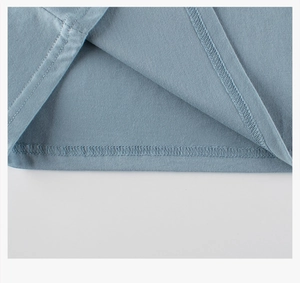 Gros plan du tissu en tricot bleu clair montrant les détails de couture du double ourlet