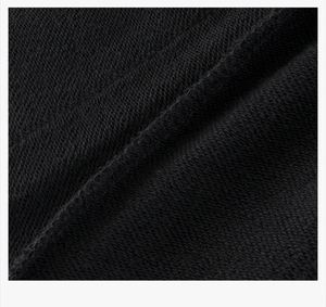 Detailed macro shot of black cotton French terry fabric texture on kids sports pants
