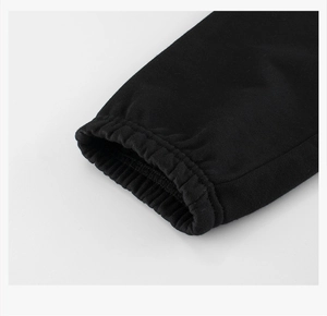 Detailed close-up of elastic ribbed cuffs on black cotton joggers for kids