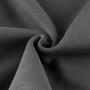 Macro shot of dark grey knit fabric texture showing premium combed cotton quality