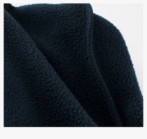 Macro detail of navy blue polar fleece fabric showing texture and reinforced edge stitching