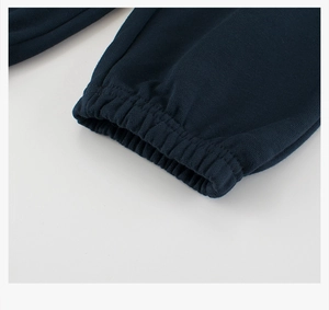 Gros plan des poignets élastiques sur un pantalon de jogging bleu marine de haute qualité