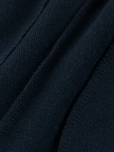 Gros plan sur la texture du coton bleu marine et les coutures du pantalon de sport enfant