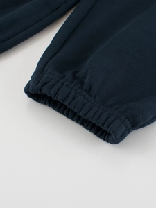 Gros plan du pantalon de jogging bleu marine montrant le tissu en maille et l'élastique