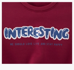 Close-up of wine red sweatshirt featuring ribbed neckline and blue 3D bubble lettering