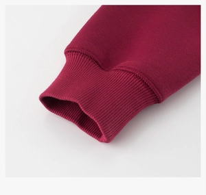 Detailed close-up of ribbed cuffs on a burgundy fleece sweatshirt for kids and teens