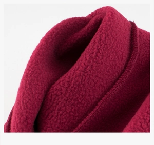 Macro shot of thick burgundy polar fleece fabric texture with durable overlock stitching