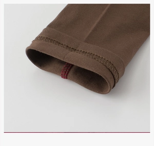 Détail de double couture et fil de surjet rouge sur t-shirt en tricot marron enfant