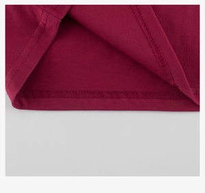 Détail de l'ourlet du t-shirt bordeaux avec une couture à double aiguille soignée
