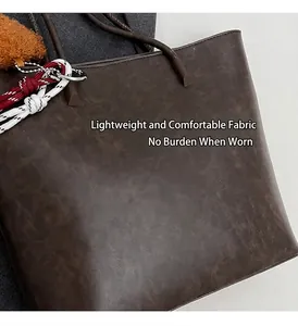 Detail einer dunkelbraunen Tragetasche mit matter Vintage-Textur und Plüsch-Anhänger