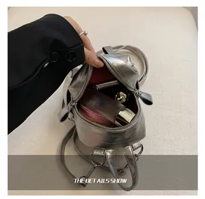 Intérieur d'un mini sac à dos argenté montrant la capacité pour le maquillage
