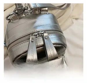 Détail du sac à dos argenté en PU avec fermetures éclair et ferrures métalliques de qualité