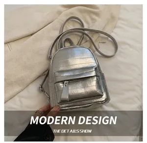 Détail du mini sac à dos argenté matelassé avec poche zippée et poignée élégante