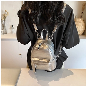 Détail du mini sac à dos argenté montrant la texture métallique et les bretelles réglables
