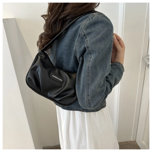 Détail du sac croissant noir plissé avec étiquette Fashion & Bag sur veste en jean