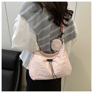 Detail of light pink pleated nylon crossbody bag with matching round coin purse accessory
