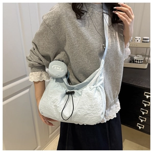 Light blue nylon crossbody bag with drawstring closure and matching round coin purse detail