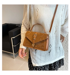 Detail of brown faux snake skin flap and gold buckle on a chic vintage handbag