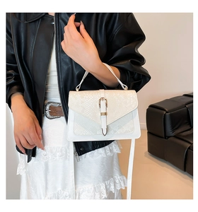 Close-up of white snakeskin texture leather handbag with vintage metal buckle detail