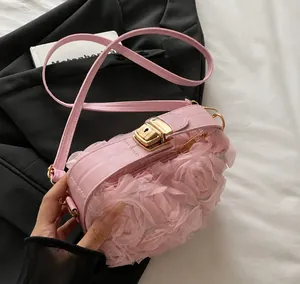 Close-up of pink shoulder bag featuring 3D mesh flowers and gold-tone metal lock buckle