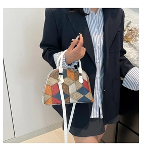 Détail du sac à main géométrique coloré avec des fermoirs dorés et une bandoulière blanche